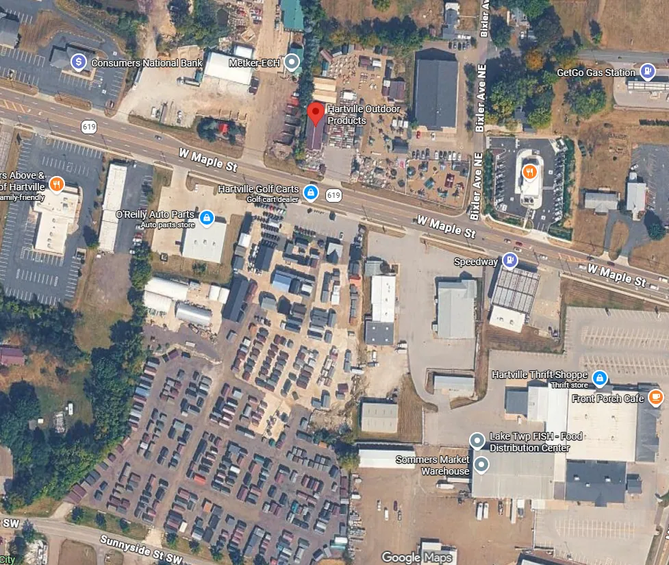 2026 aerial view of the same stretch of West Maple Street, with the land south of the road packed with rows of sheds, barns and buildings